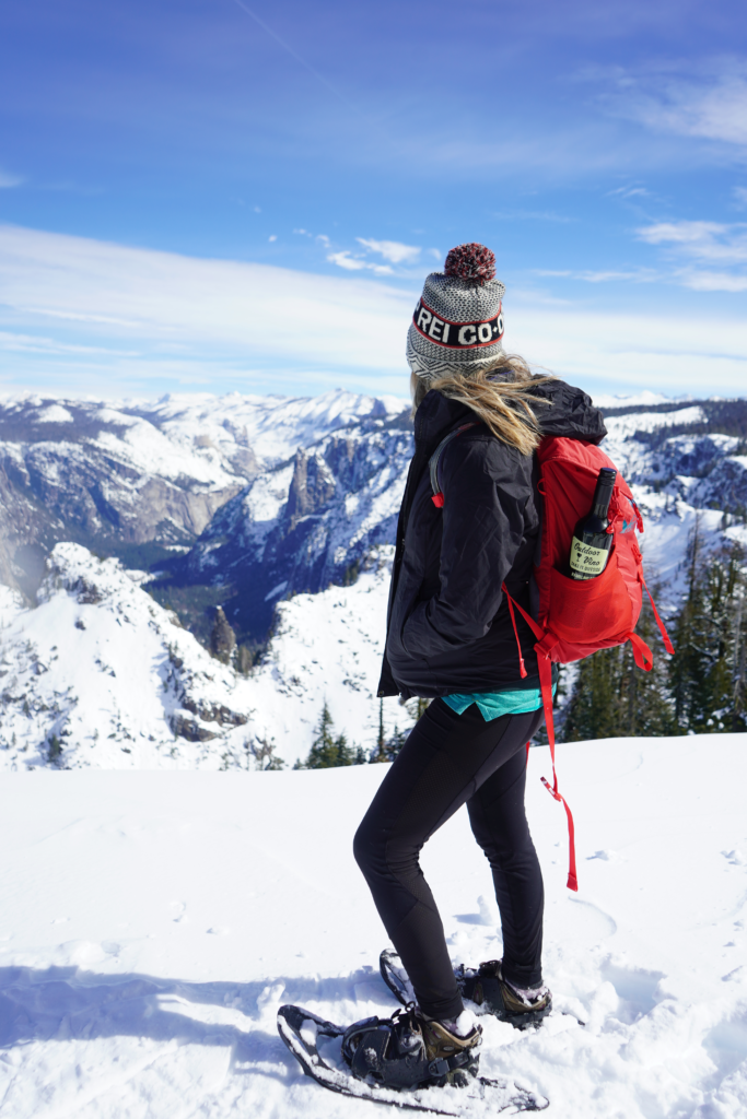 Black Jacket and Leggings with Snowshoes and Red Backpack — Winter Hiking Outfits